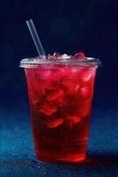 Refreshing red drink served in a clear cup with ice photo