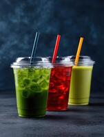 Refreshing iced beverages in colorful cups on dark backdrop photo