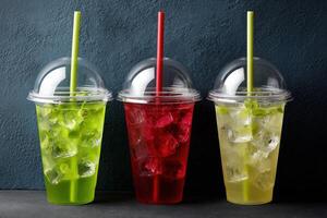 Colorful drinks served in clear cups with ice and straws photo