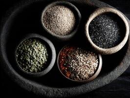 Colorful assortment of spices and seeds in stone bowls photo
