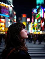 Young woman gazes at neon lights in busy urban street photo