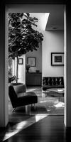 Black and white photo of a living room with a tree