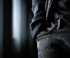 Close-up of jeans with a relaxed pose in a dimly lit room photo