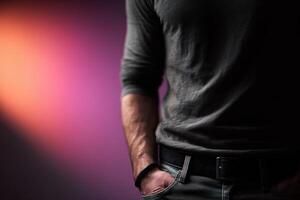 A man in a gray shirt and jeans standing in front of a purple light photo