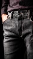 Dark denim jeans worn by a model in a studio setting photo