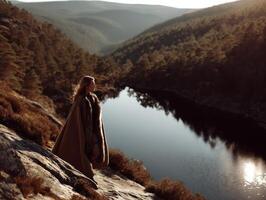 Viking woman standing by a tranquil lake in a mountainous landscape photo