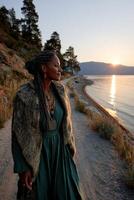Viking woman standing by the water at sunset with a serene expression photo