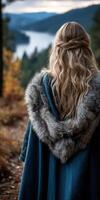 Viking woman in a forest with a fur-trimmed cloak during autumn photo