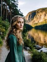 Viking woman standing by tranquil lake with mountains in background photo