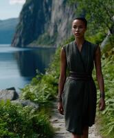 Viking woman walking along a fjord surrounded by lush greenery photo