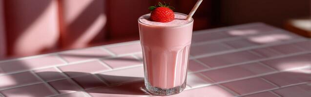 Delicious strawberry protein shake served in a glass on a pink table photo