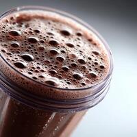 Protein shake in a blender cup with frothy texture and bubbles photo