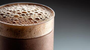 Delicious protein shake served in a clear glass with frothy bubbles photo