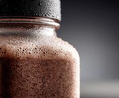 Refreshing protein shake in a glass jar with frothy texture photo