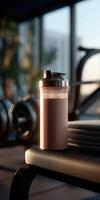 Protein shake sits on bench in gym during evening workout session photo
