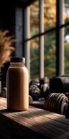 Protein shake on wooden table in gym with weights nearby photo