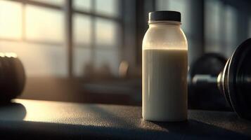 Protein shake sits on gym bench near weights during workout photo