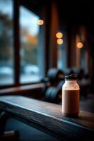 Protein shake resting on wooden bench near gym window in evening light photo