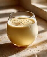 Protein shake served in a glass on a sunny kitchen counter photo