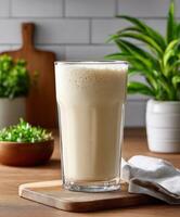 Refreshing protein shake served in a clear glass with greenery nearby photo