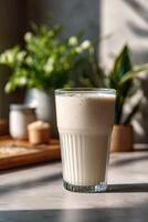 Protein shake served in a tall glass with plants in background photo
