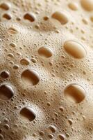 Creamy protein shake with bubbling froth on a textured surface photo