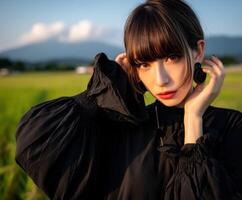 Portrait of a woman in black attire against a scenic backdrop photo