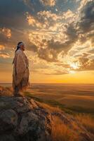 Indigenous person gazes over vast landscape at sunset photo
