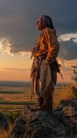 Native American man standing on rocky hillside during sunset photo