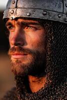 Warrior in chainmail reflecting on the battlefield at sunset photo