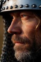 Warrior in chainmail helmet gazes intently on battlefield at dawn photo