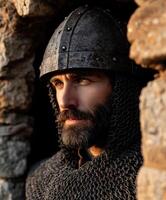 Historic warrior in armor gazing from stone fortress at sunset photo