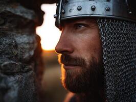 Warrior in chainmail gazes at sunset in historical landscape photo