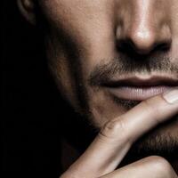 Close-up of a man pondering in deep thought against a dark background photo