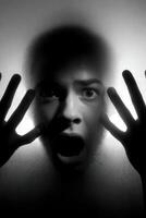 Person expresses fear while pressed against a fogged glass surface photo