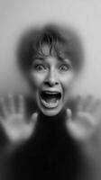 Woman expressing fear with hands against a foggy surface photo