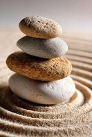 Balanced stone arrangement on sand with gentle ripples in background photo