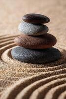 Stones stacked in a tranquil arrangement on smooth sand background photo