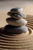 Stack of stones on textured sand in a tranquil setting photo
