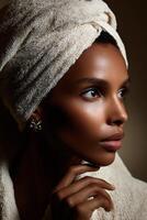 Woman with a towel on her head posing elegantly in soft lighting indoors photo