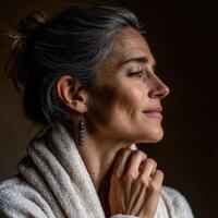 Woman in soft robe with elegant earrings reflects in peaceful moment photo