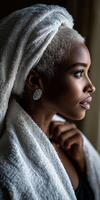 Woman in a towel and earrings gazes thoughtfully out of a window photo