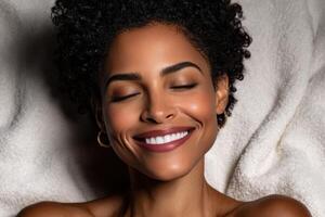 Smiling woman with curly hair enjoys relaxation on soft blanket photo