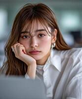 Portrait of a young woman with a thoughtful expression in a modern workspace photo
