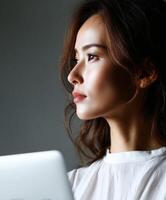 Woman working on laptop in a relaxed indoor setting during daytime photo
