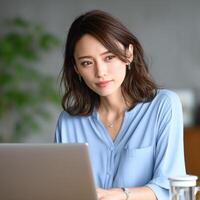 Professional woman focused while working on laptop in modern office space photo