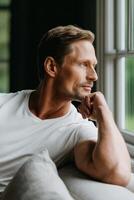Man relaxes while contemplating life in a cozy indoor setting photo