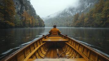 Man in a boat on a lake surrounded by trees photo
