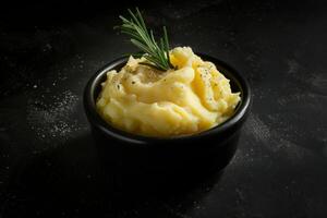 Soft and fluffy serving of mashed potatoes with freshly-cracked black pepper and chives photo