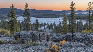 A view of the mountains and trees at sunrise photo